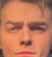 a close up of a young man staring at the camera